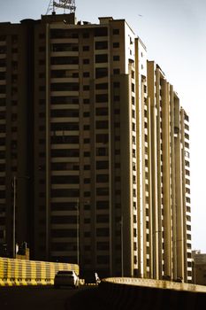 Majestic high-rise building in Karachi captured under bright daylight, showcasing architectural symmetry.