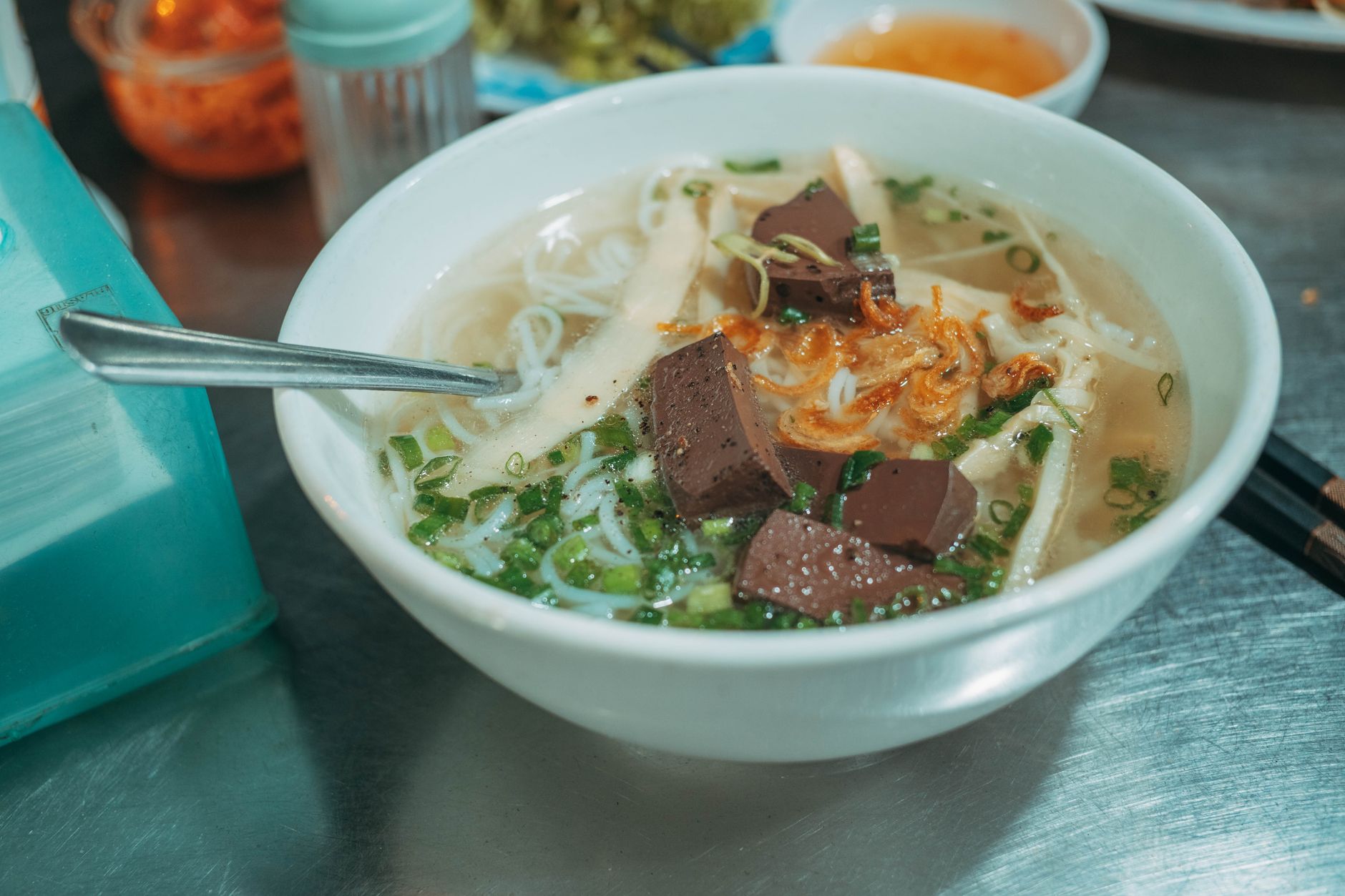 Appetizing bowl of Vietnamese pho with beef, fresh herbs, and savory broth served in a white bowl.