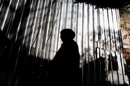 Free Silhouette of a person in front of a corrugated metal wall with striking shadows in Istanbul, Türkiye. Stock Photo