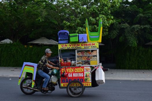 Motorcycle street food vendor selling snacks in a vibrant urban environment.