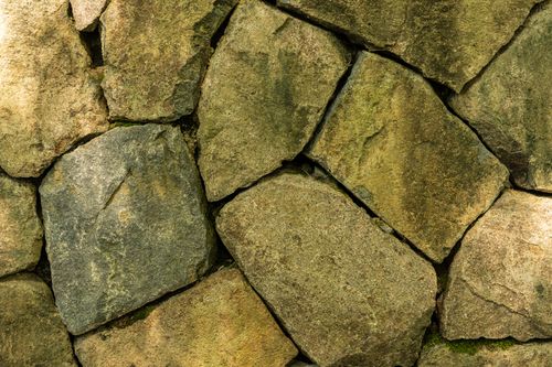Free Detailed view of a textured rustic stone wall, showcasing natural earthy shades. Stock Photo