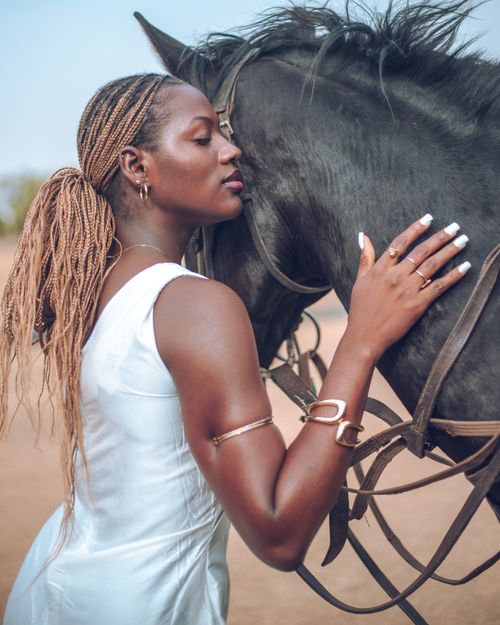 Free An African woman affectionately embracing a horse in an outdoor setting in Zaria, Nigeria, conveying warmth and connection. Stock Photo