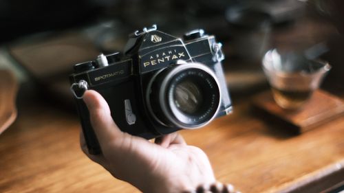Free Closeup of a classic Asahi Pentax Spotmatic camera held by a hand, highlighting its vintage design. Stock Photo