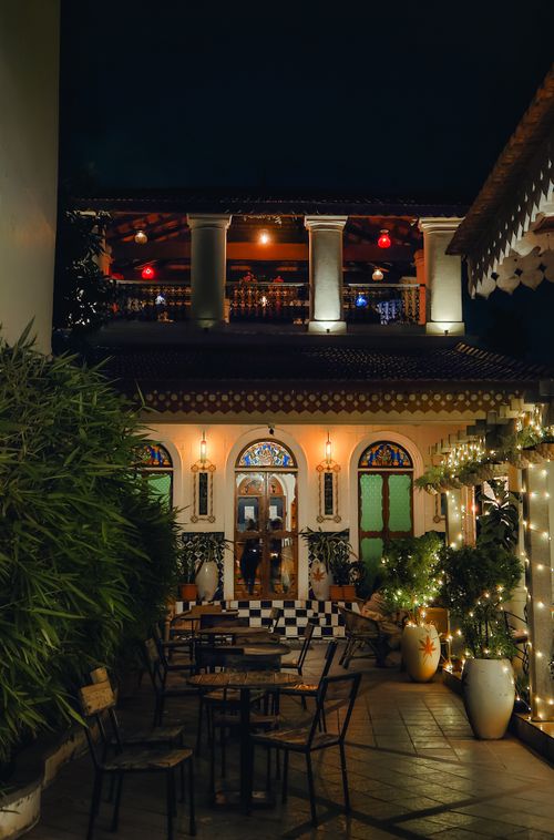 Free Charming outdoor café setting in Puducherry at night, featuring lights and elegant architecture. Stock Photo