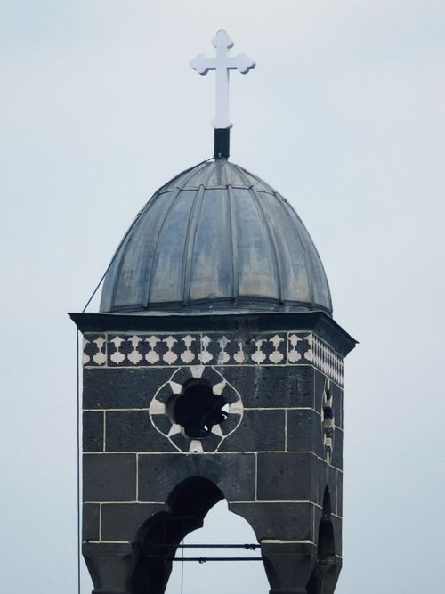Free Stone church tower with a dome and cross, showing Gothic architectural elements. Stock Photo