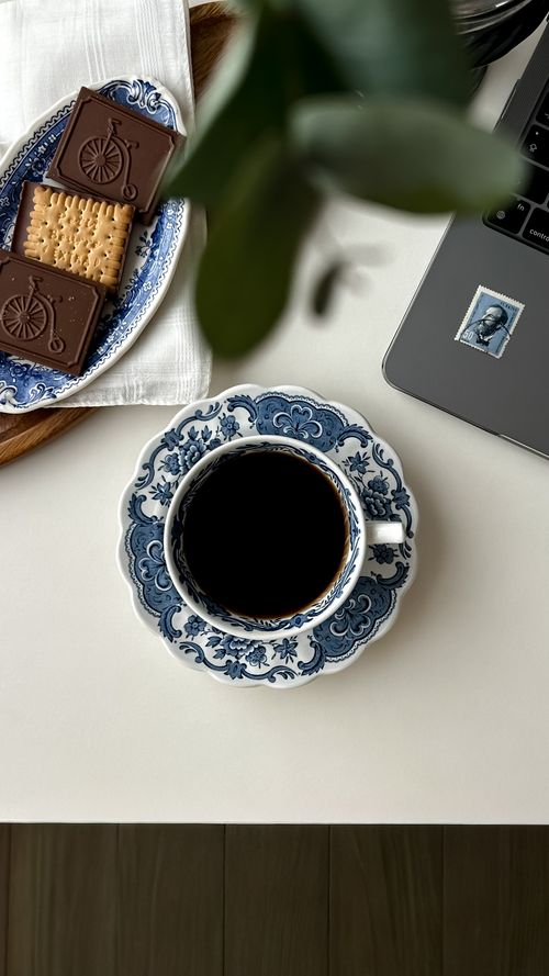 Free Top view of a coffee cup with cookies and a laptop on a table, creating a cozy workspace vibe. Stock Photo