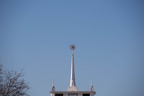 Free A building spire topped with a star against a clear blue sky, symbolizing architectural elegance. Stock Photo