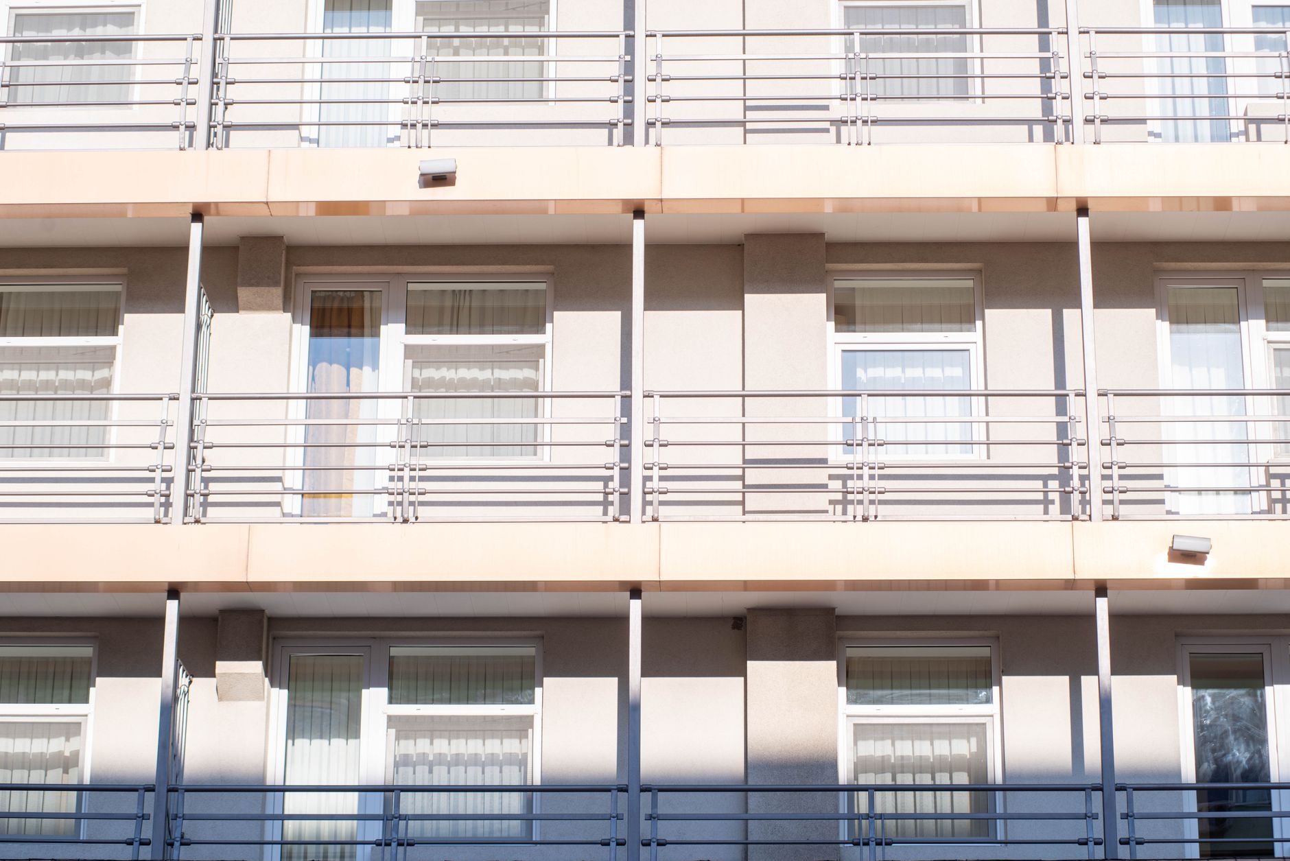 A clean view of a contemporary apartment building exterior showcasing balconies and windows.