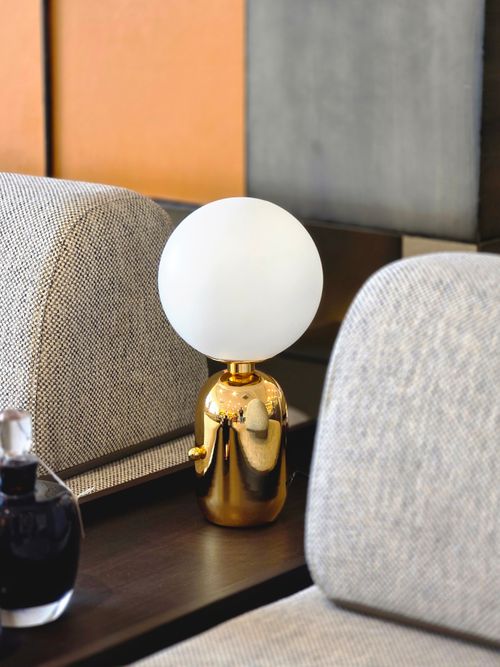Free A stylish gold table lamp with a globe bulb in a luxurious interior setting. Stock Photo