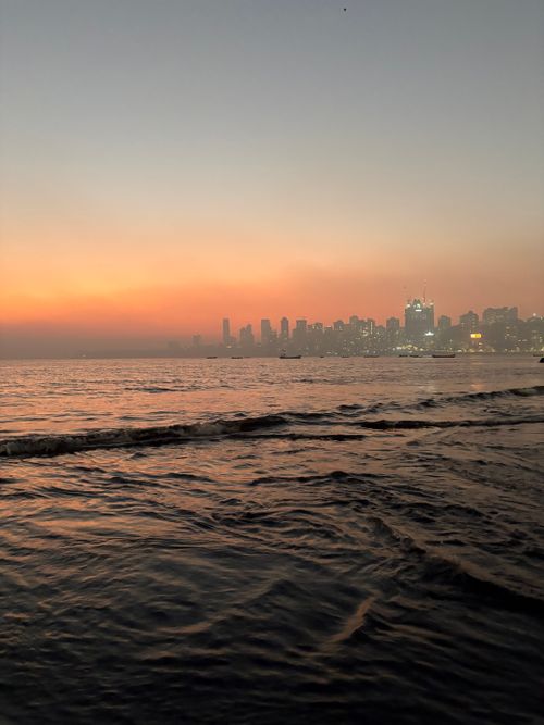 Free Breathtaking view of Mumbai skyline during sunset with vibrant colors reflecting on the sea. Stock Photo