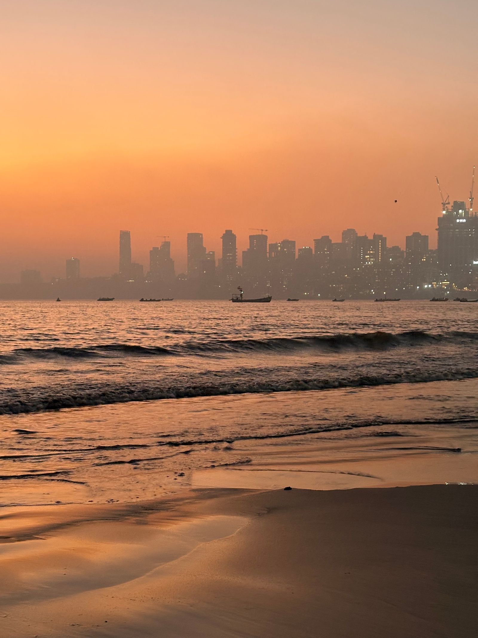 A sunset over the ocean with a city skyline in the background · Free ...