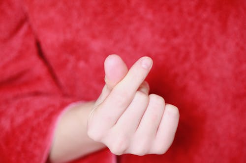 Persons Hand on Red Textile