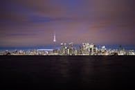 多伦多天际线的夜间景观令人惊叹，标志性的加拿大国家电视塔在黑暗的天空中熠熠生辉