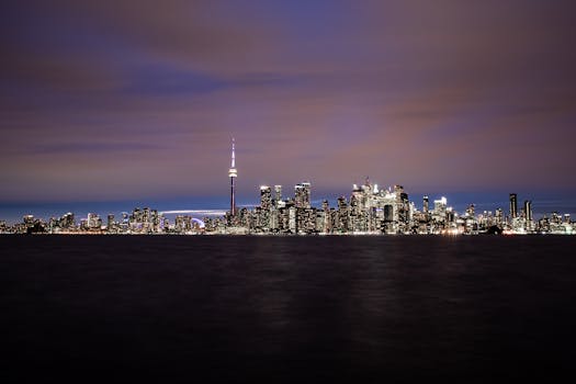多伦多天际线的夜间景观令人惊叹，标志性的加拿大国家电视塔在黑暗的天空中熠熠生辉