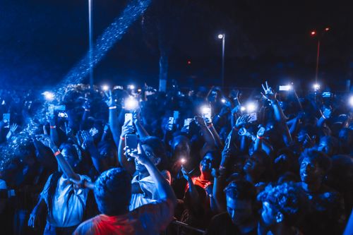 Free Vibrant nighttime concert crowd with illuminated phones and energetic atmosphere. Stock Photo