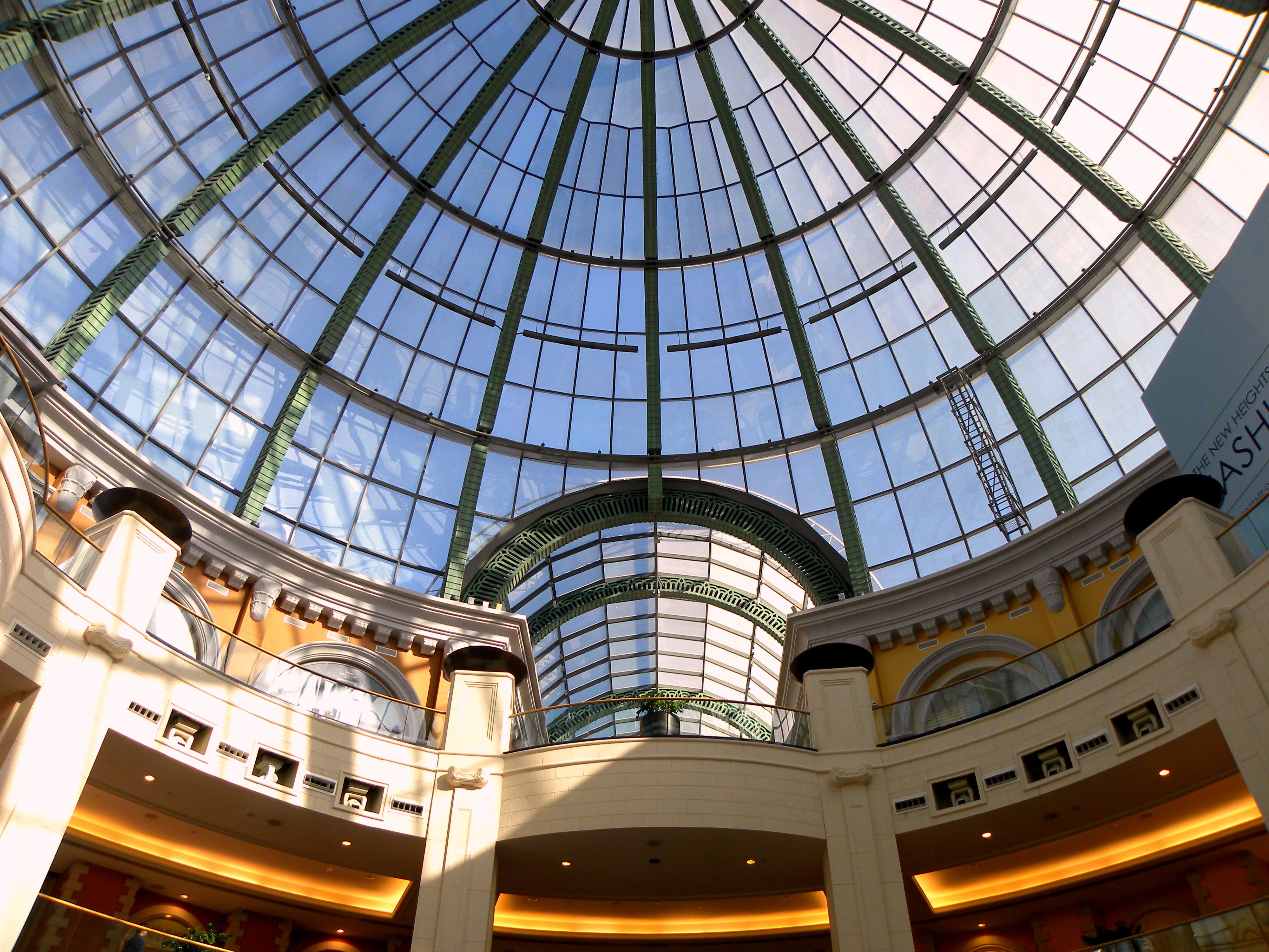 Stunning view of the glass dome ceiling inside Mall of the Emirates, Dubai, with sunlight streaming through.