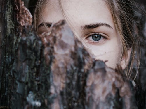 Ruhige Frau Hinter Baumrinde Im Park