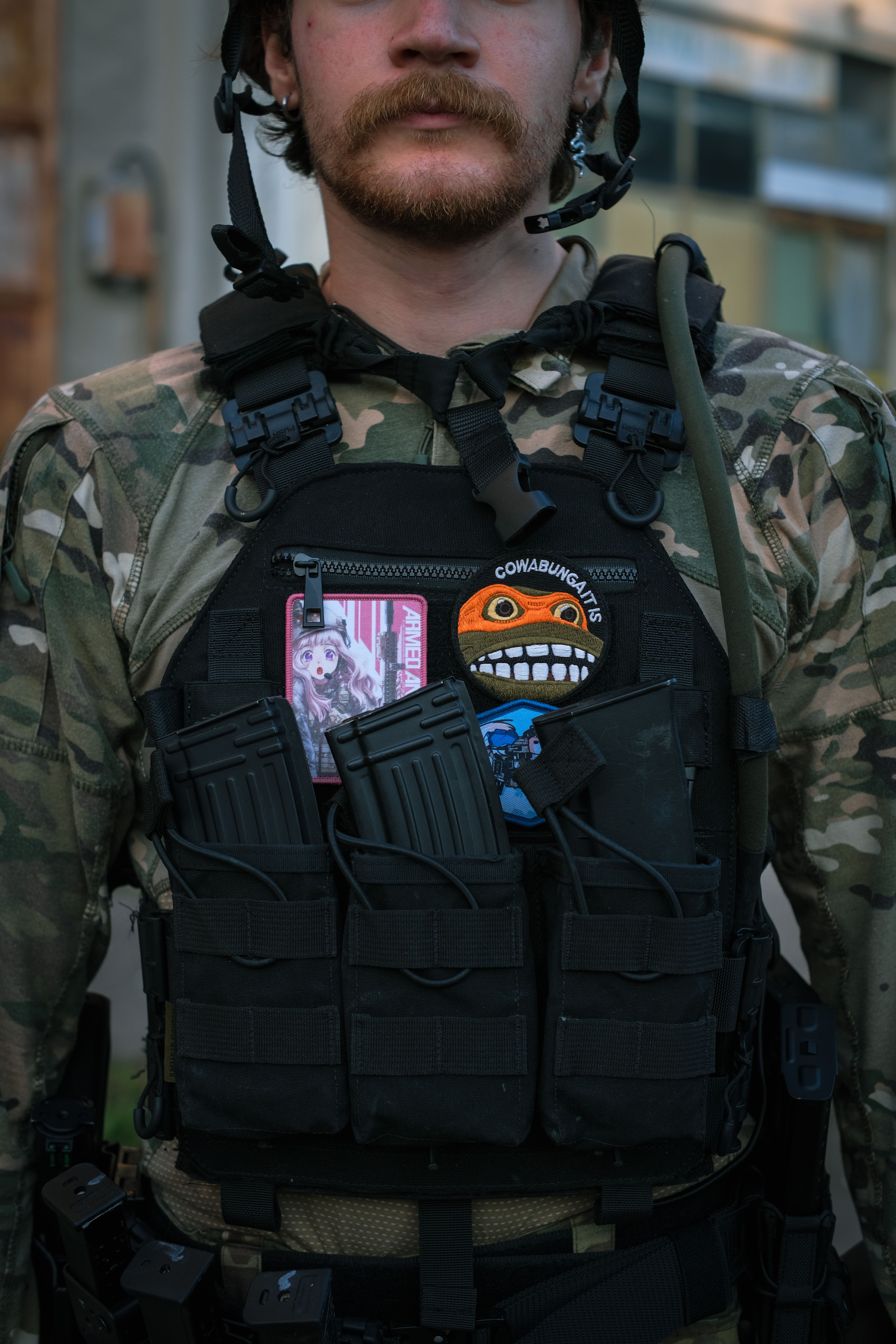 Close-up of a tactical vest with patches and magazines, perfect for airsoft enthusiasts.