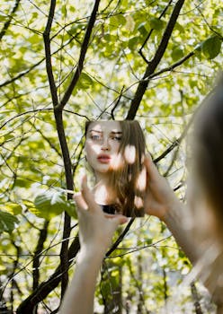 一名女子凝视着镜子，镜面被鲜艳的绿叶环绕，映出一幅梦幻般的肖像