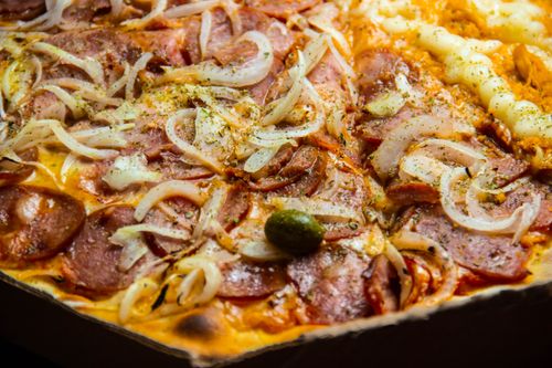 Free Mouth-watering close-up of pepperoni and onion pizza, seasoned to perfection. Stock Photo