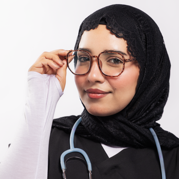 Close-up of a female doctor wearing a hijab and glasses, exuding confidence.