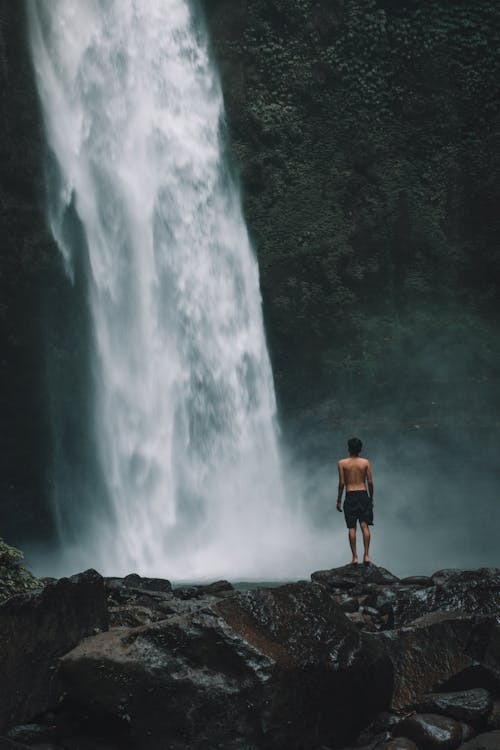 Homme Debout Sur Un Rocher Près De Cascades