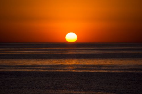 Free Stunning view of the sun setting over the tranquil Atlantic Ocean, Colonia del Sacramento, Uruguay. Stock Photo
