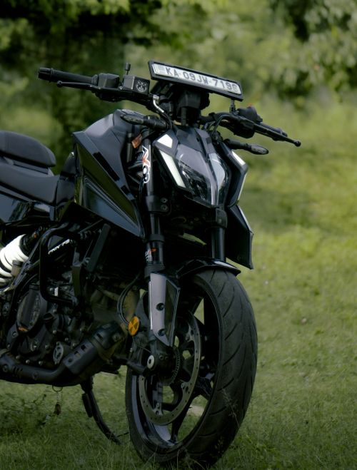 Free Sleek black motorcycle with license plate parked on lush green grass, showcasing modern design and outdoor vibe. Stock Photo