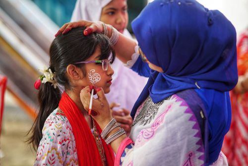 Free A woman paints a child's face at a vibrant cultural festival. Stock Photo