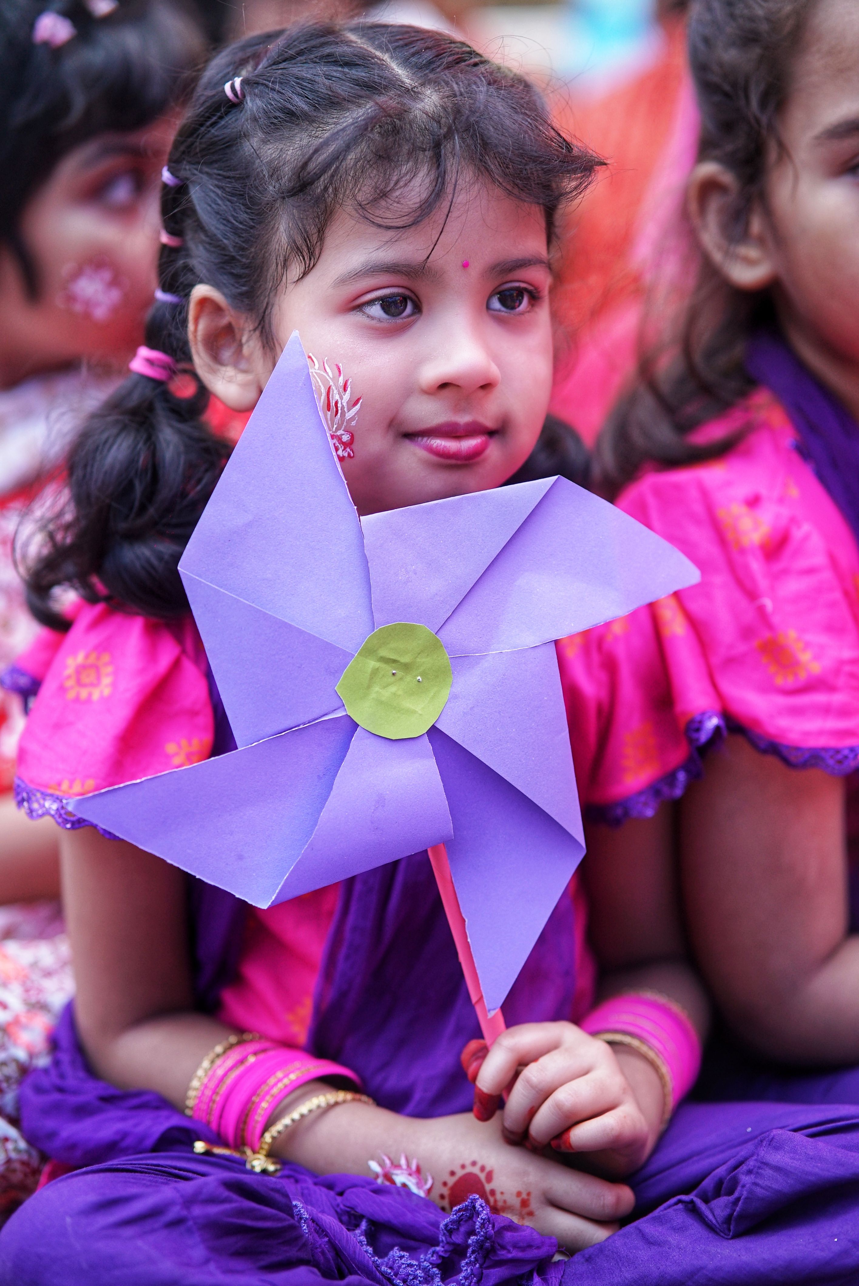 Young Girl Holding Purple Pinwheel at Festival · Free Stock Photo