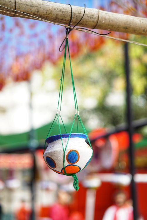 Free Close-up of a vibrant hand-painted pot hanging at an outdoor market, showcasing cultural art. Stock Photo