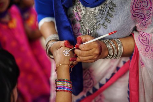 Free Close-up of a woman applying henna during a vibrant cultural celebration. Stock Photo