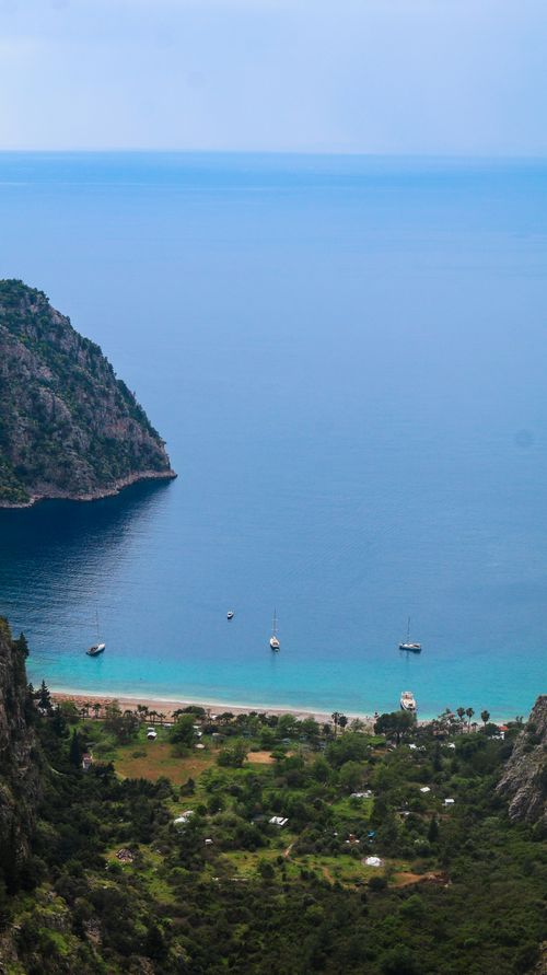 Free Breathtaking aerial view of a tranquil Mediterranean beach with clear turquoise waters and boats. Stock Photo