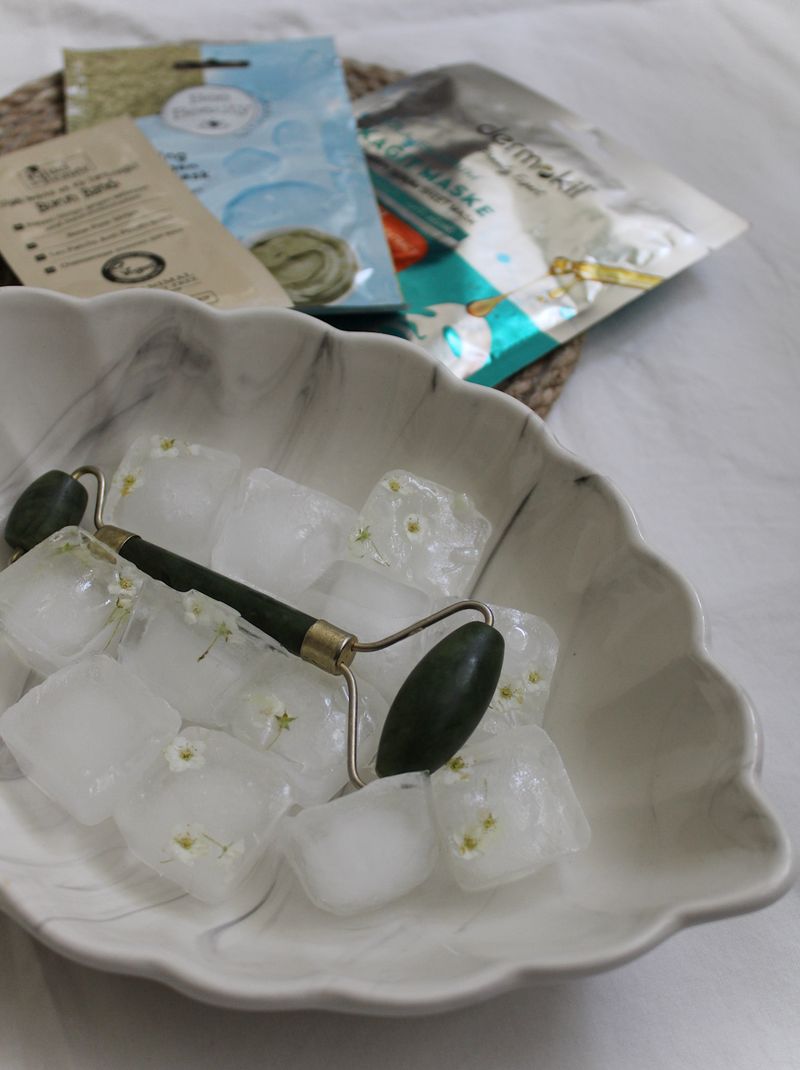 A jade roller resting on ice cubes