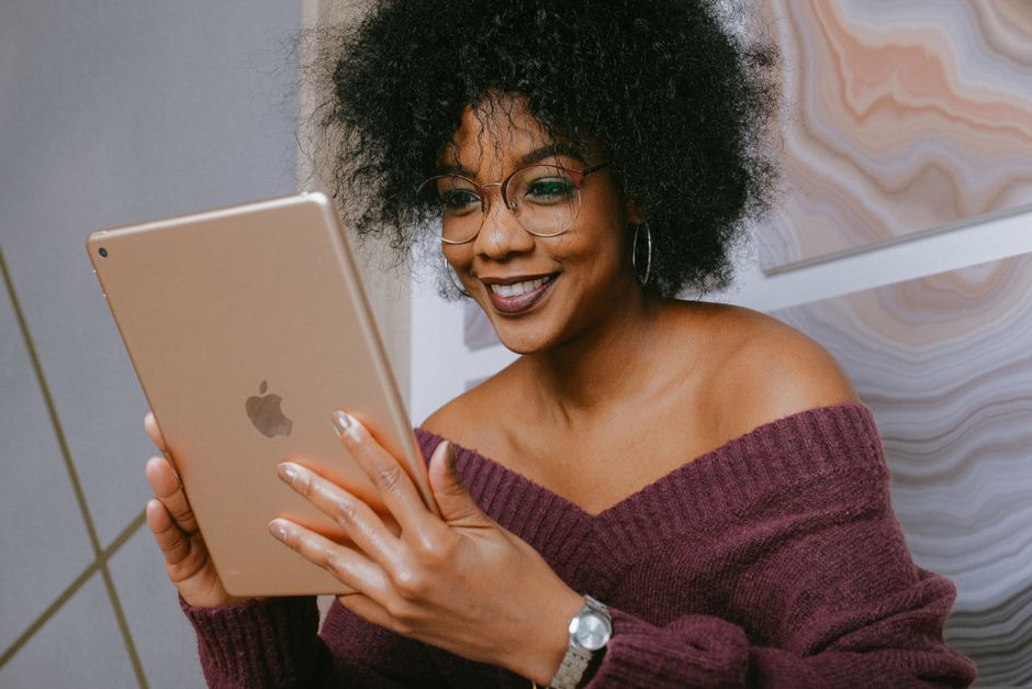 person smiling while reading positive reviews on a tablet - cleaning services somerville ma person smiling while reading positive reviews on a tablet - cleaning services somerville ma