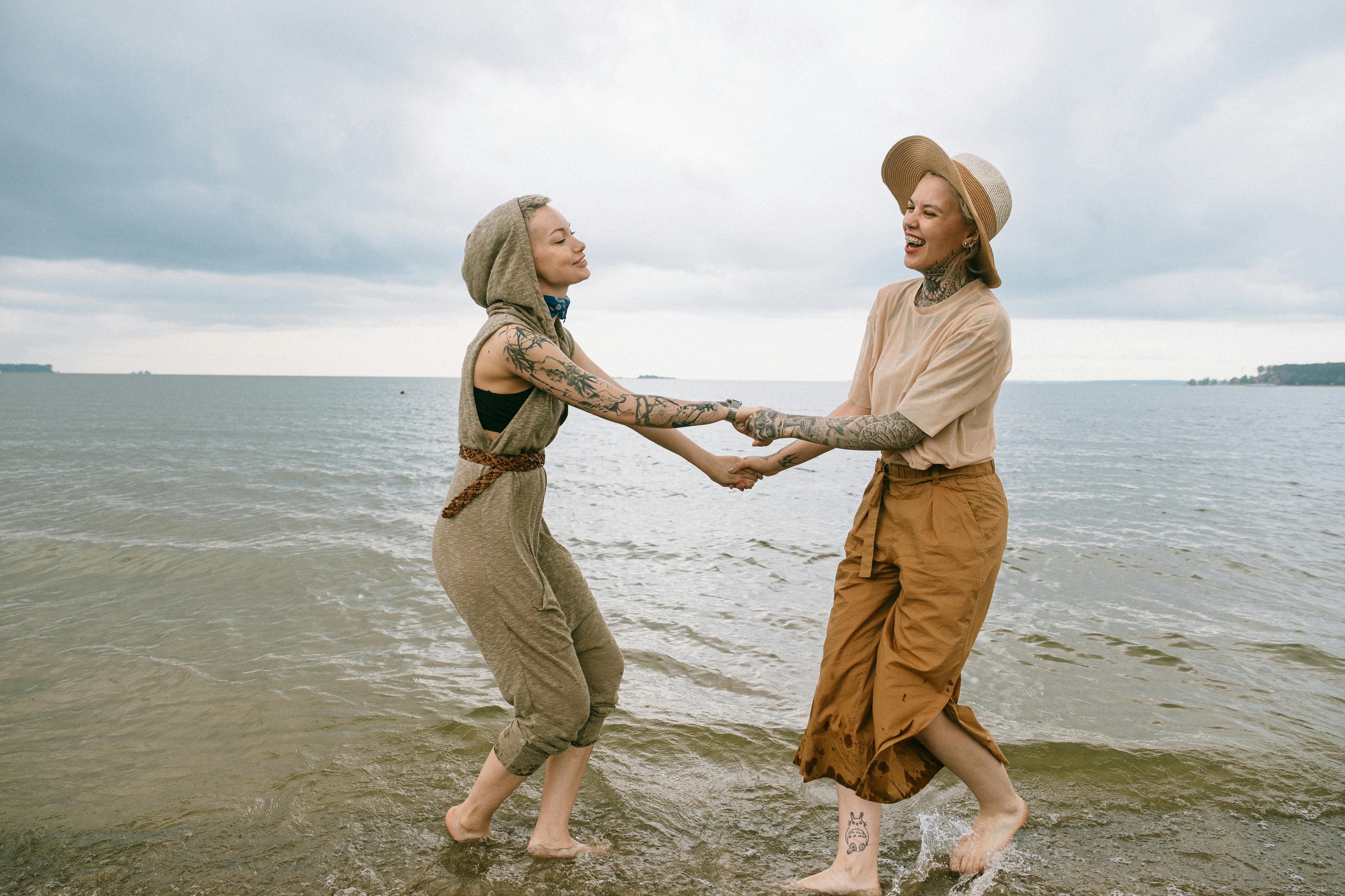 women holding hands on beach