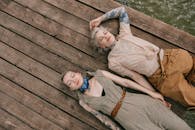 两名纹身女子躺在木甲板上，捕捉着无忧无虑的放松时刻