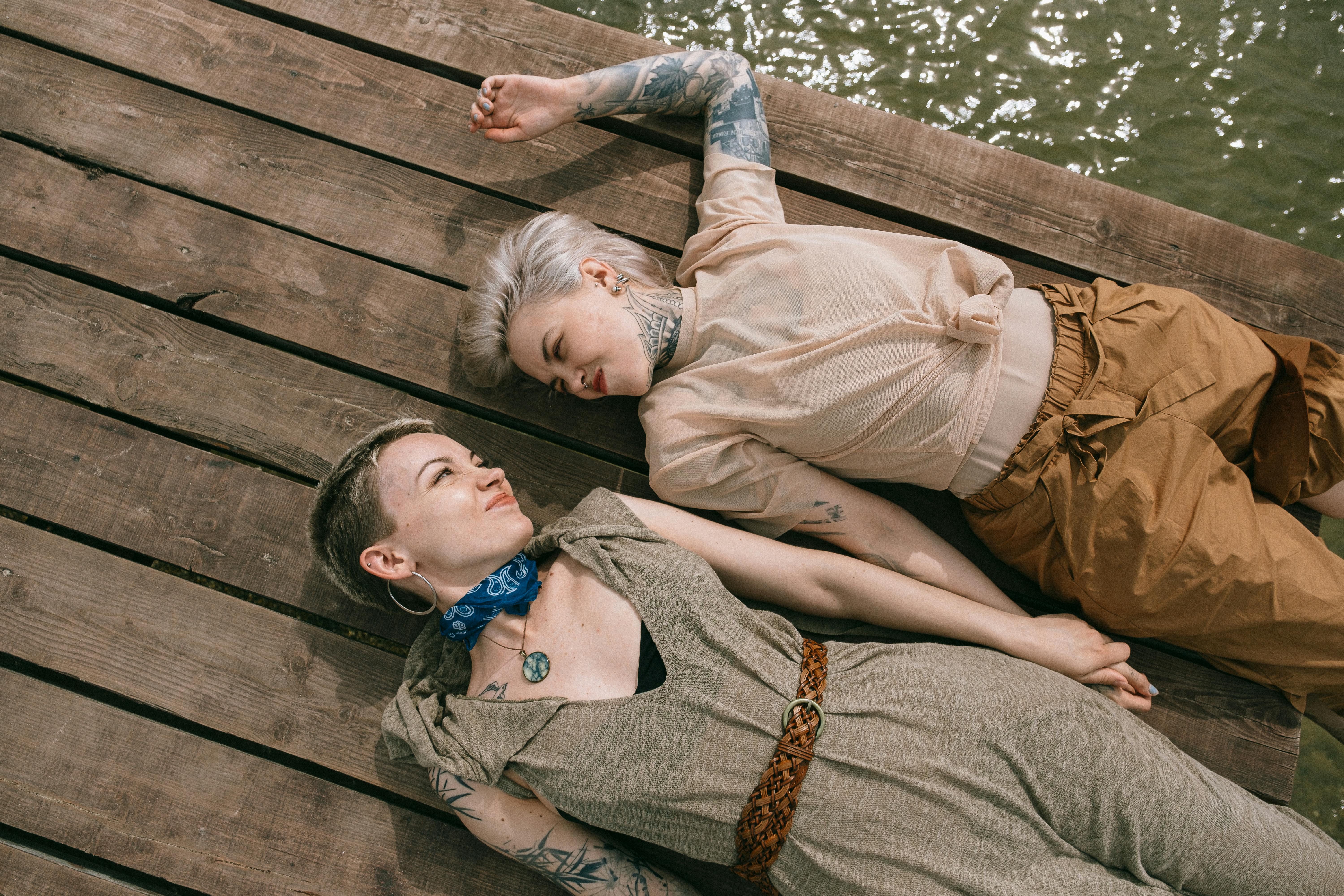 high angle photo of women lying down on wooden planks