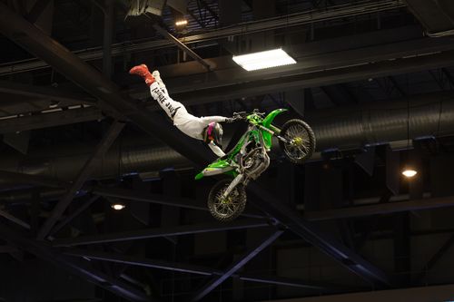 Free A thrilling motocross stunt performed indoors, showcasing extreme sports action. Stock Photo
