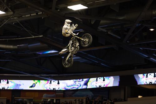 Free Daring motocross stunt performed indoors with biker in mid-air leap. Stock Photo