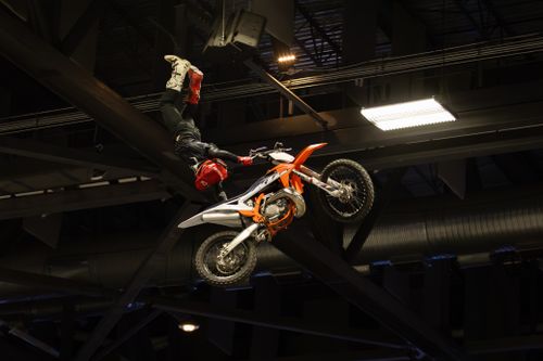 Free Exciting motocross stunt performance in an indoor arena, showcasing extreme skill and precision. Stock Photo