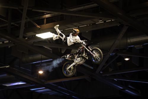 Free Daring motocross stunt performance during an indoor event. Stock Photo