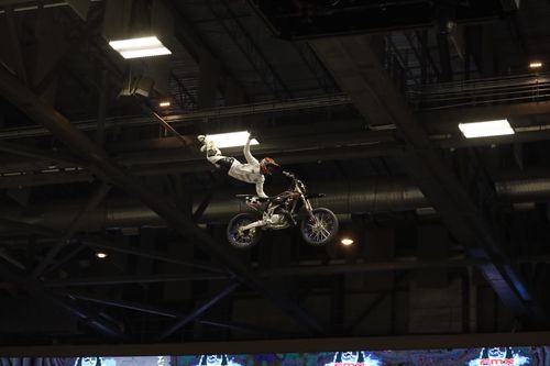 Free A motorcycle rider executes a thrilling mid-air stunt in an indoor arena, showcasing extreme sports dynamics. Stock Photo