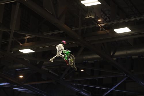 Free A skilled motocross rider performs a daring stunt indoors. Stock Photo