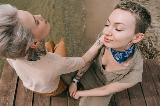 两名女子坐在水边的木板路上，享受着片刻的宁静