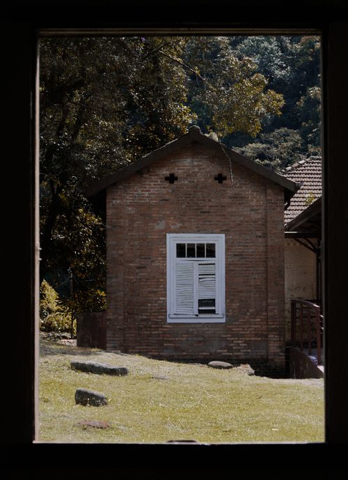 Free View through a window of a charming brick house surrounded by nature in São Paulo, Brazil. Stock Photo