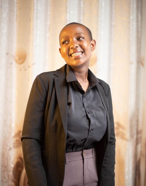 Free Confident young adult in a black suit smiling warmly indoors. Stock Photo