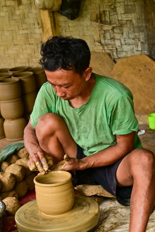 Free Artisan skillfully molds clay on a pottery wheel in traditional workshop. Stock Photo