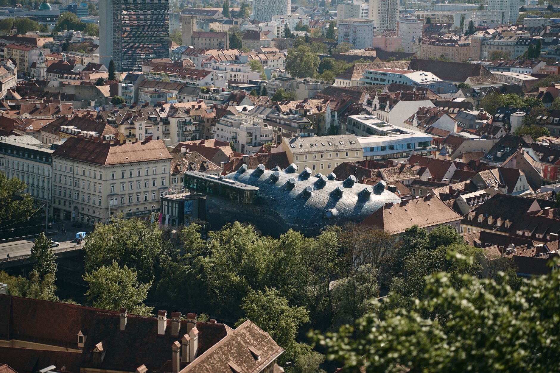 Aerial view of Graz, Austria featuring the iconic Kunsthaus Graz surrounded by historical architecture.