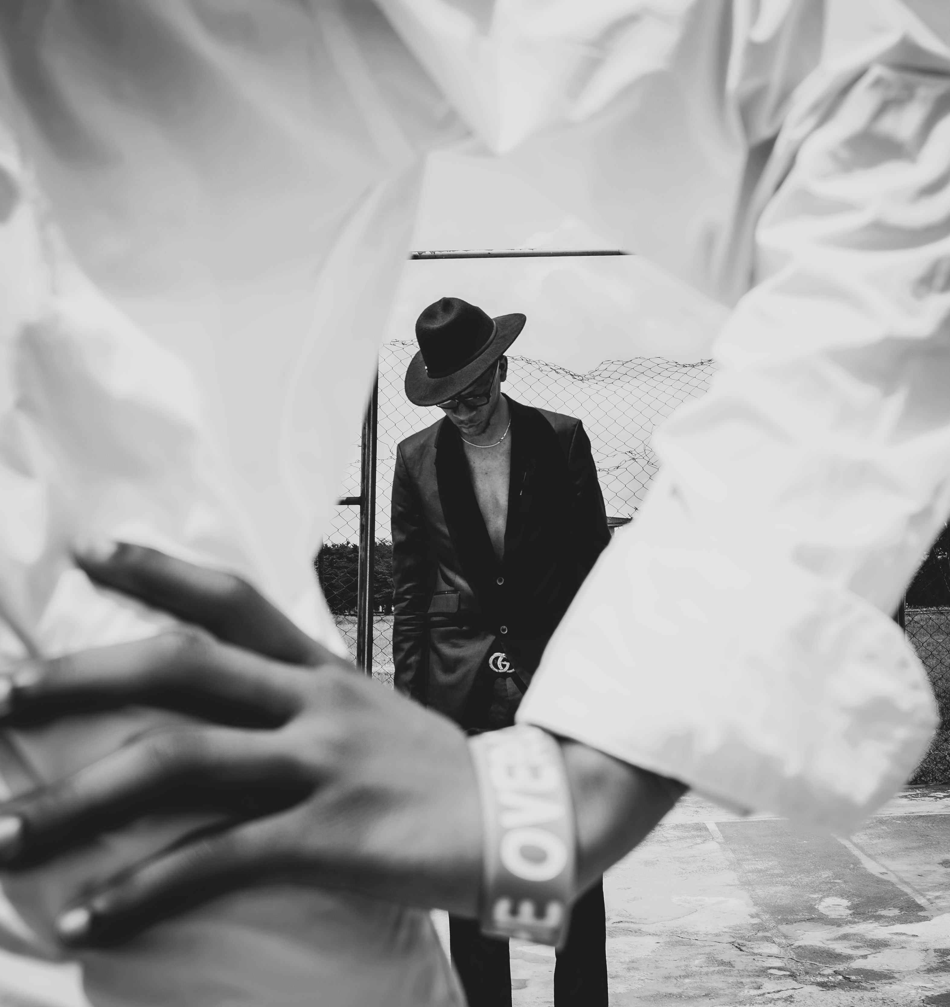Artistic black and white portrait of a stylish man in a hat, showcasing modern fashion.